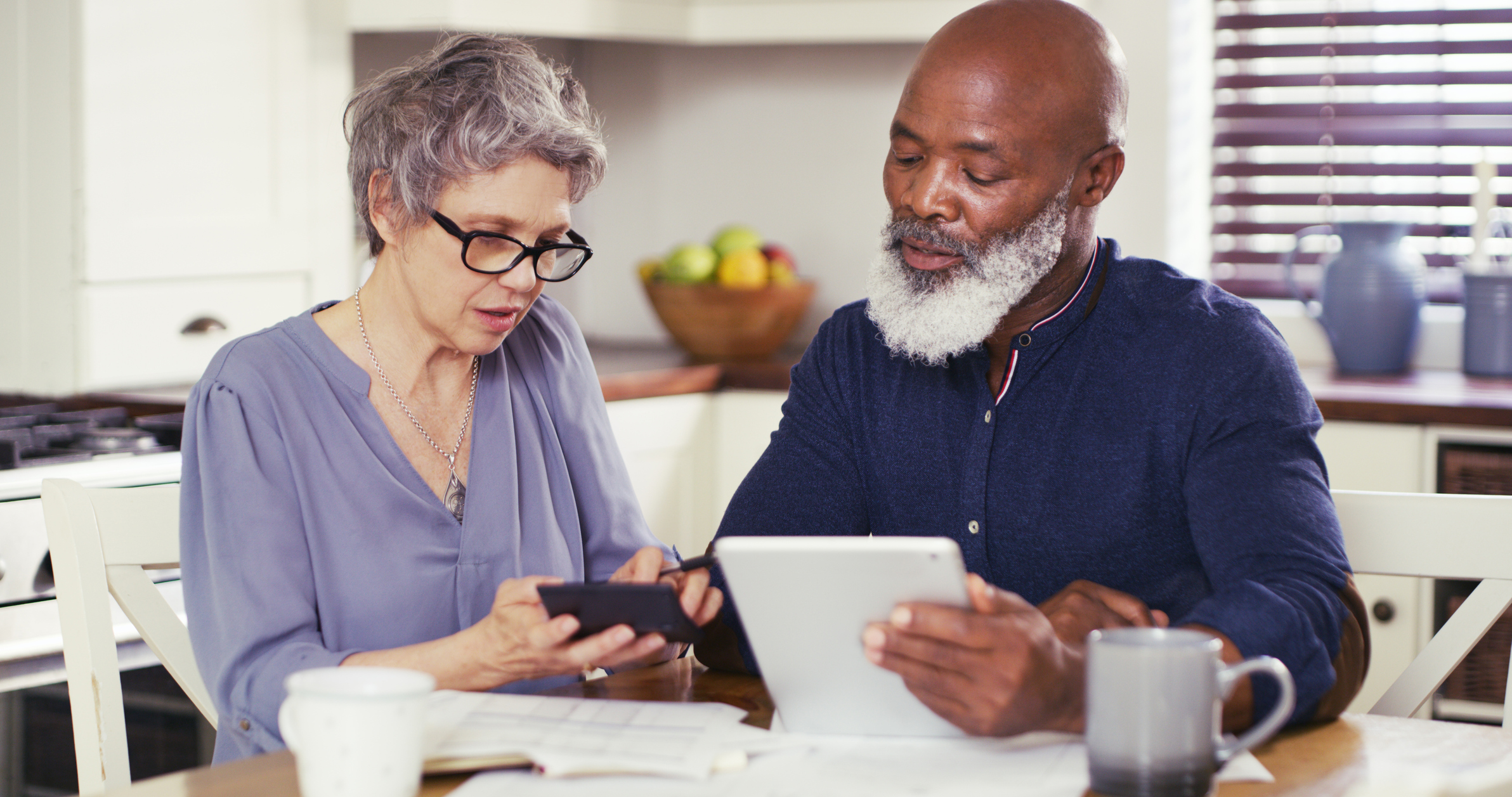 Shot of a mature couple using a digital tablet while working on their budget together at home