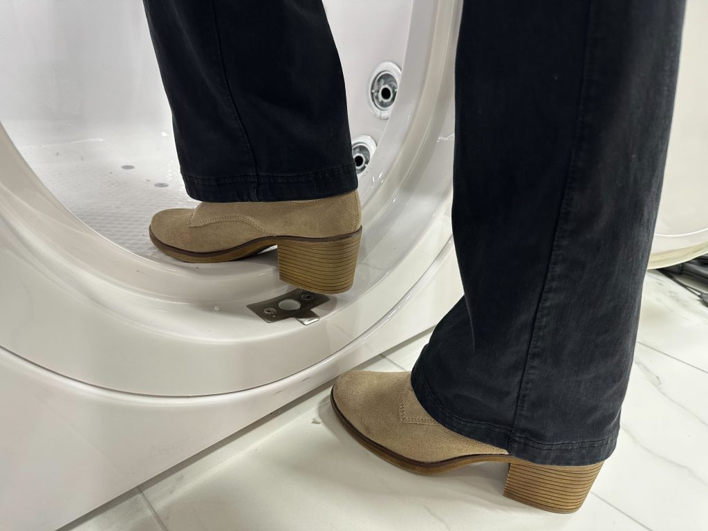 Retirement Living's editor testing the threshold height of a walk-in tub. Pictured is a 4-inch threshold