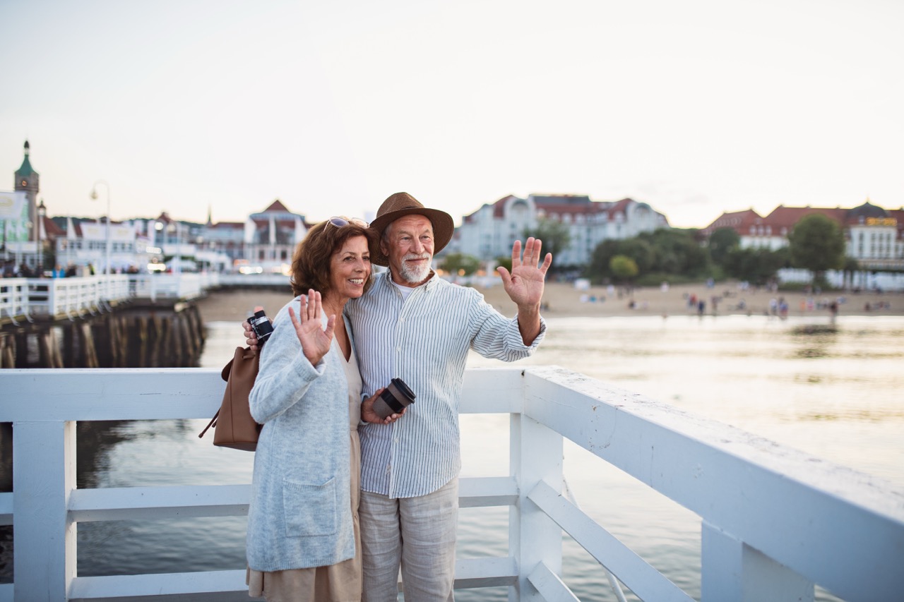 Feature image happy-senior-couple-vawing-outdoors-on-pier-by-sea