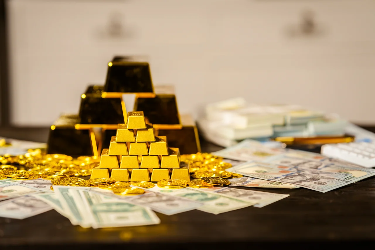 gold-bars-stacks-of-cash-sit-on-a-table-at-night