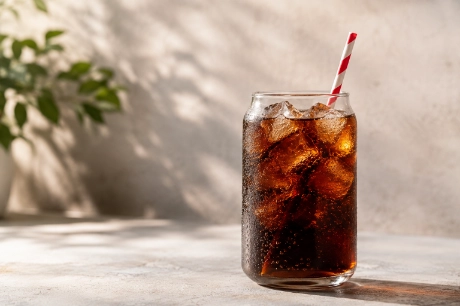 A glass of soda with a striped straw