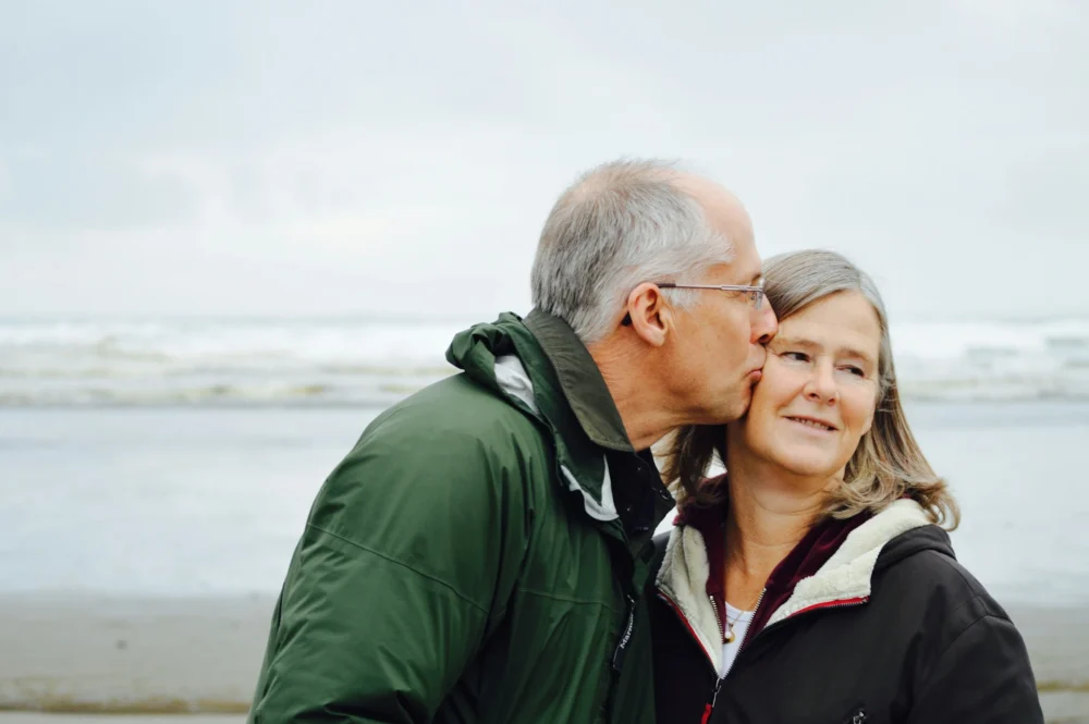 Man kissing woman on the beach: Photo by Esther Ann on Unsplash